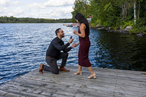 Anthony Lombardo proposing on a wooden dock by the lake to Veronica Reyes
