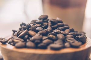 A close up photo showing a pile of dark freshly roasted beans.