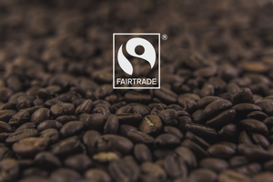 Certified Fair Trade logo overlaid on top of a photo of our high quality roasted beans, roasted in Canada
