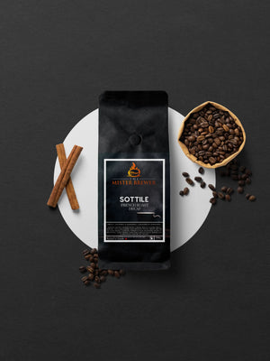 A packaged bag of Sottile Swiss Water Decaffeinated dark French roast coffee beans, with coffee beans scattered around, and a cinnamon stick partially visible to the side.